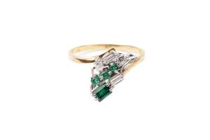 An emerald and diamond ring in 18 carat yellow gold