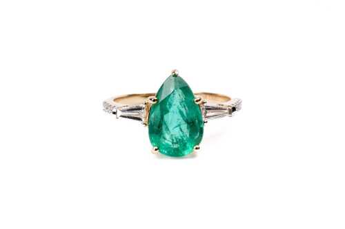 An emerald and diamond ring in 14 carat yellow gold