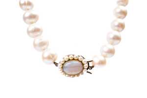 An Opera length strand of pearls to an opal and pearl clasp in 9 carat yellow gold