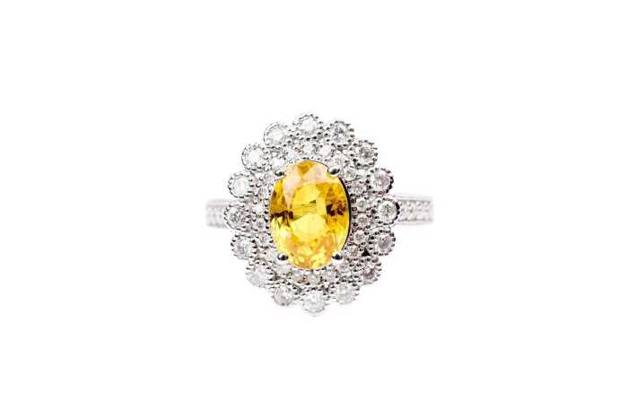 A yellow sapphire and diamond ring in 14 carat white gold