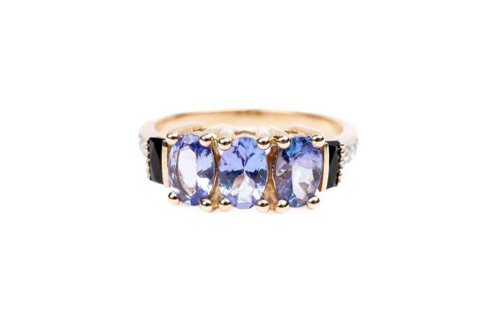 A tanzanite, diamond, and onyx ring in 9 carat yellow gold