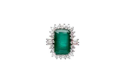 An emerald and diamond ring in 18 carat white gold