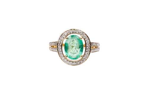 An emerald and diamond ring in 14 carat yellow gold