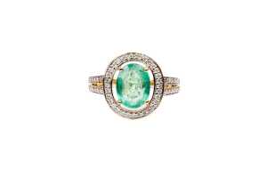 An emerald and diamond ring in 14 carat yellow gold