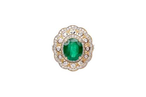 An emerald and diamond ring in 14 carat yellow gold