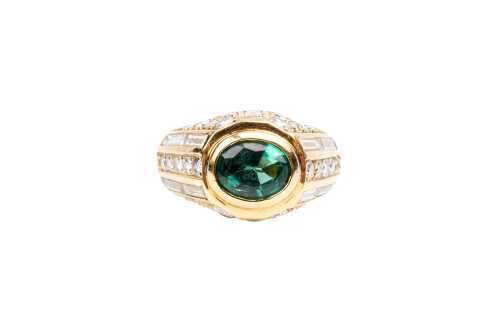 An emerald and diamond ring in 18 carat yellow gold