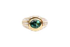 An emerald and diamond ring in 18 carat yellow gold