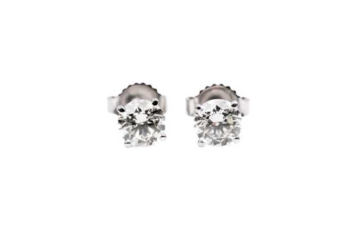A pair of diamond stud earrings in 14 carat white gold