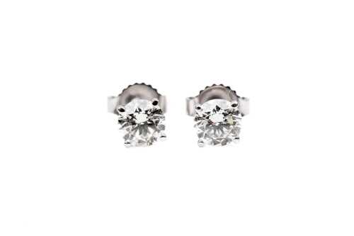 A pair of diamond stud earrings in 14 carat white gold