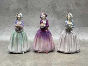 Three Royal Doulton 'Dorcas' porcelain figures in different colourways
