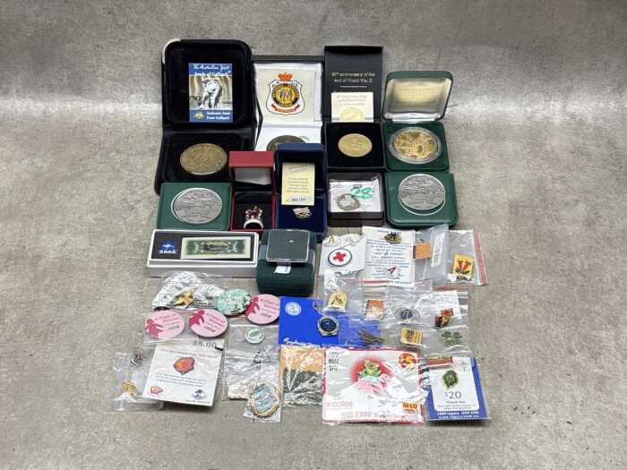 A tin of badges, medallions, and a tiny gold nugget