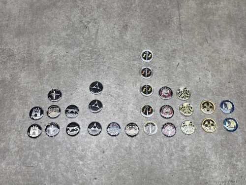 Collection of metal car themed medallions, including Ford