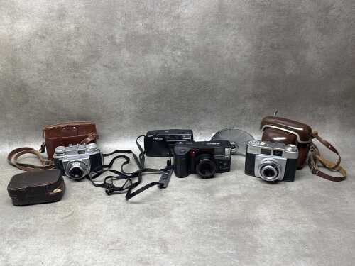 Four film cameras including Olympus, together with a flash