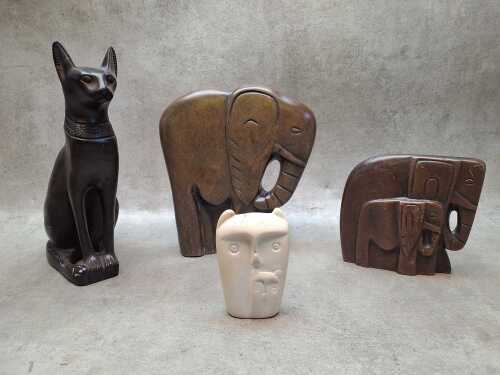Four carved stone animal figures including a pair of elephants, Egyptian Bastet and owls