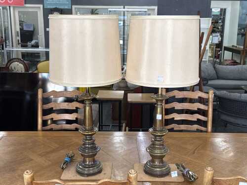 Pair of cast metal ornate table lamps with cream fabric shades