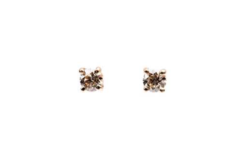 A pair of diamond stud earrings in 14 carat yellow gold