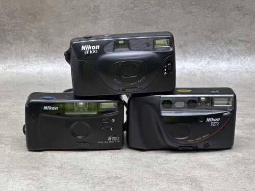 Three Nikon compact 35mm film cameras