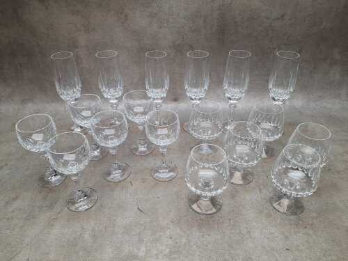Three sets of six cut crystal glassware including champagne flutes, brandy balloons and hock glasses