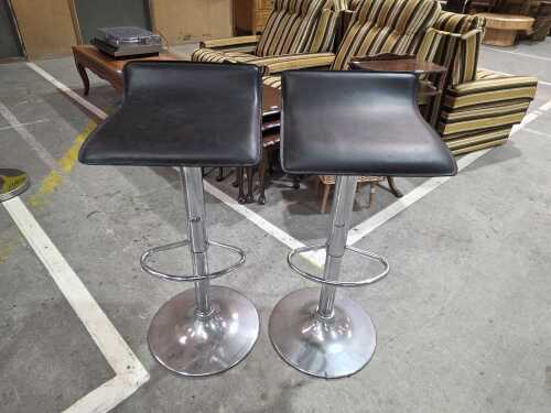 Pair of black upholstered adjustable bar stools