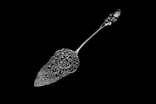 Sterling silver cake server with pierced design of roses and scrolls