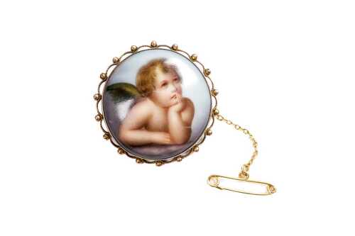 A antique porcelain cherub mourning brooch in 9 carat yellow gold