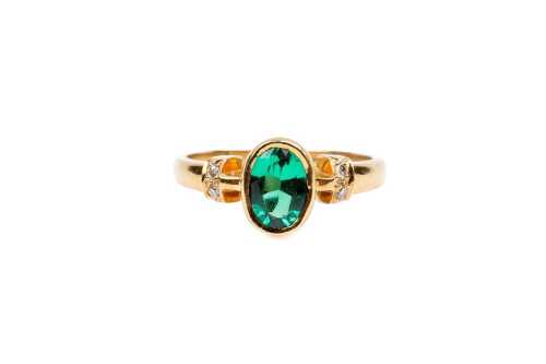 A synthetic emerald and diamond ring in 18 carat yellow gold