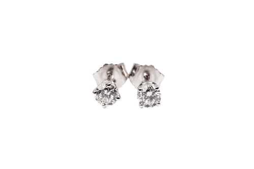 A pair of diamond stud earrings in 14 carat white gold