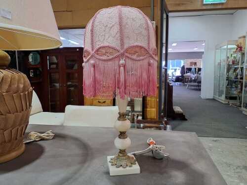 Marble and cast metal table lamp with pink lace and tasselled bell shade