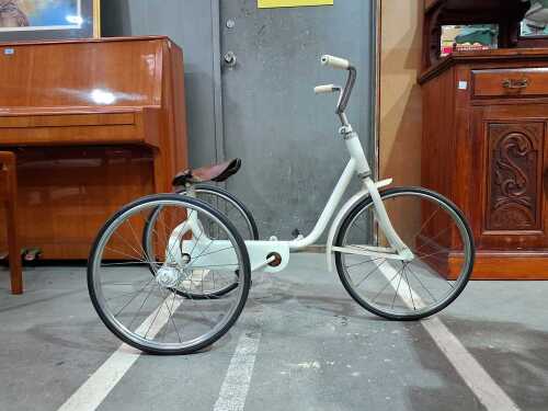 White child's tricycle with brown leather seat