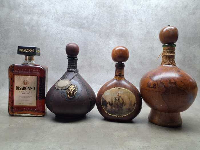 Disaronno Italian Liqueur, one bottle and three decorative empty bottles