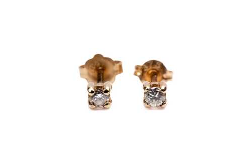 A pair of diamond stud earrings in 9 carat yellow gold