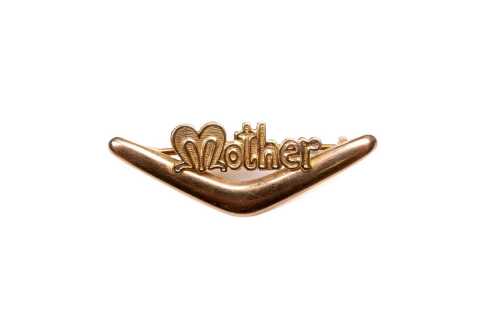 A boomerang Mother brooch in 9 carat yellow gold