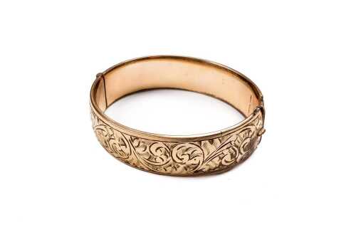 A vintage engraved metal lined 9 carat yellow gold bangle