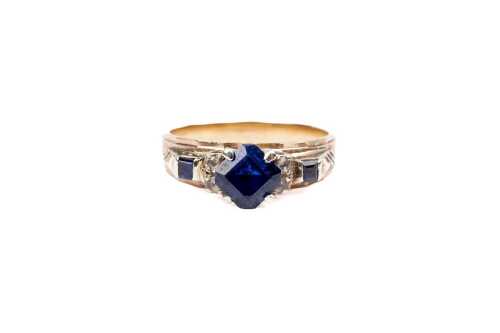 A vintage synthetic sapphire and white topaz ring in 9 carat yellow gold