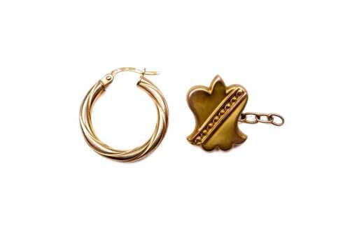 A single shield cufflink and a hoop earring in 9 carat yellow gold