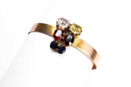 A vintage multi coloured gemstone bangle in 9 carat yellow gold
