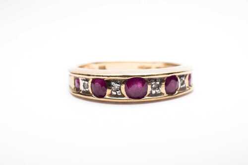 A ruby and diamond band in 9 carat yellow gold.