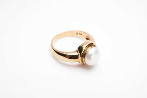 A button pearl ring in 9 carat yellow gold.