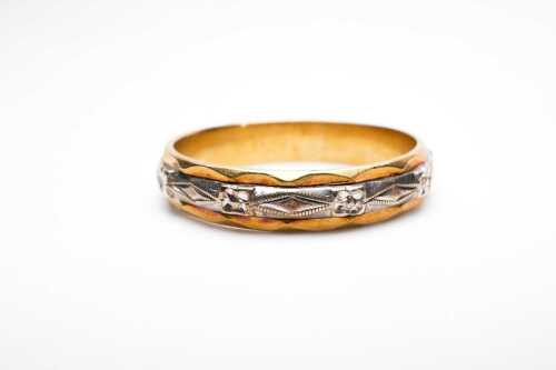 A carved band in 18ct yellow gold and palladium