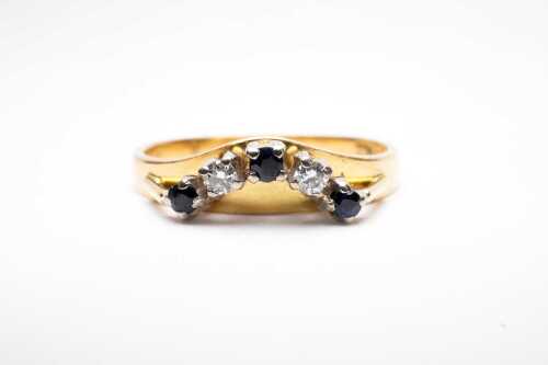 A sapphire and palladium curved eternity ring in 18ct yellow gold.
