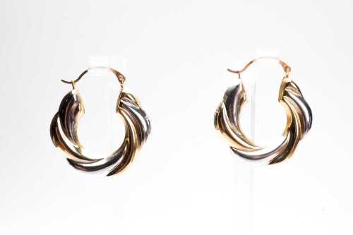 A pair of twist hoops in 14 carat yellow and white gold.