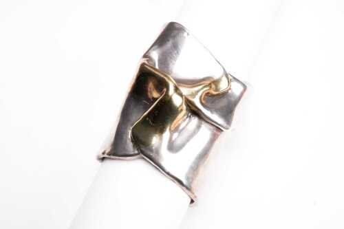 A vintage organic sculptural cuff bangle in sterling silver and gold-plate.