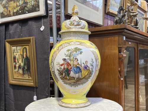 Antique porcelain urn with hand-painted scenes and flowers on a yellow ground