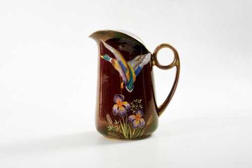 A Carlton Ware Rouge Royale with hand painted flying duck and iris porcelain jug