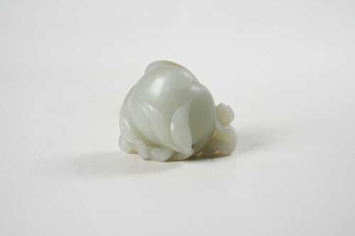 A jade carving depicting a monkey on a peach