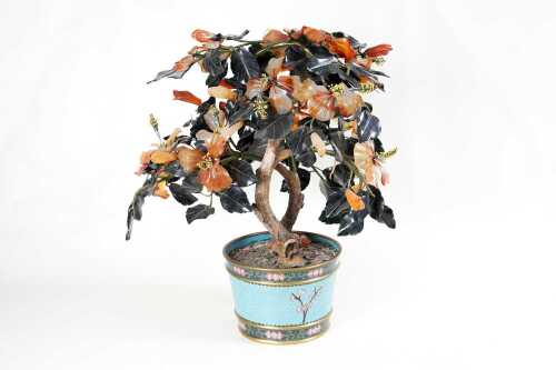 An Oriental stone carved hibiscus in cloisonne pot