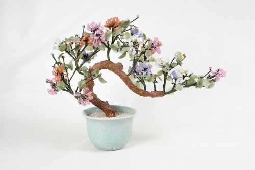 An oriental carved stone bonsai in celadon pot