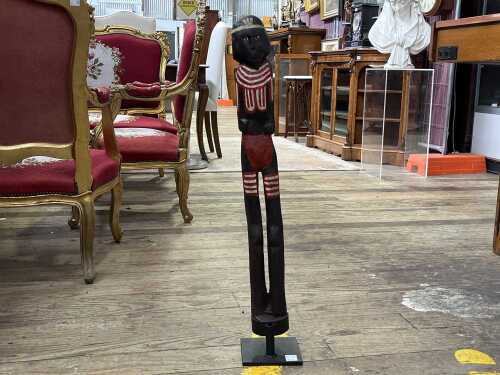 Indigenous hand-carved male figure on metal base.