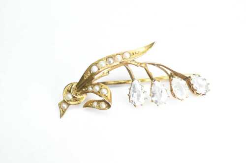 An antique aquamarine and seed pearl floral brooch in 9ct yellow gold.
