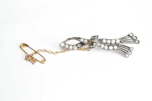 An antique diamond ribbon brooch in 14ct yellow gold.